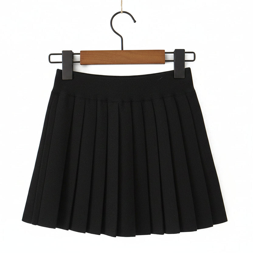 A black pleated mini skirt hanging from a wooden hanger with black clips against a plain white background.